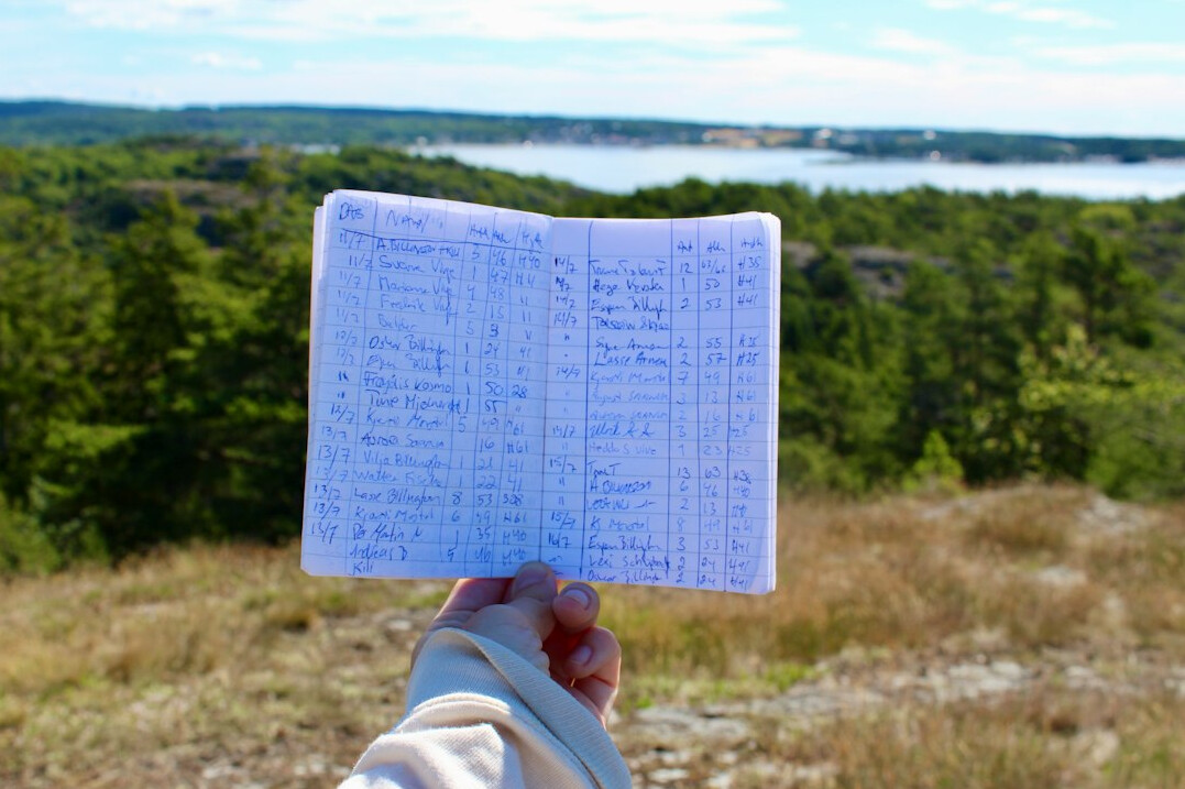 Hands writing notes in a notebook with documents nearby