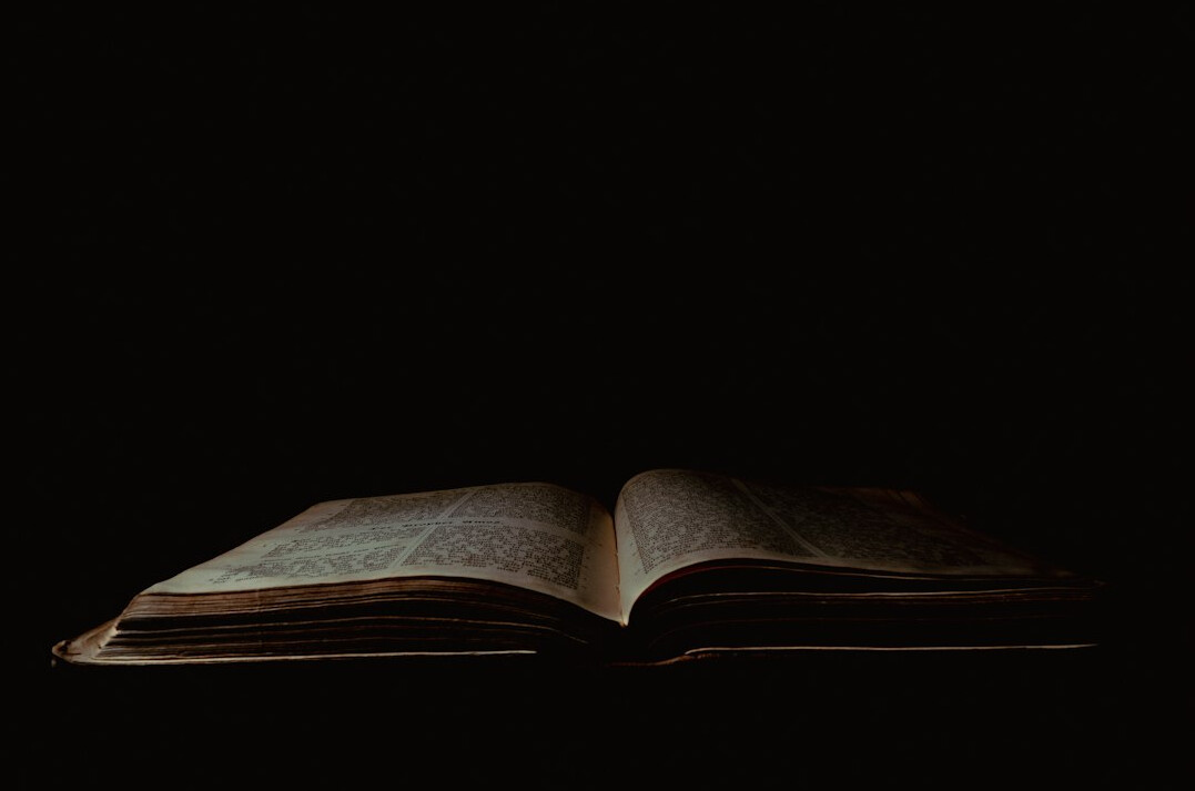 Open book with dramatic lighting on a dark table
